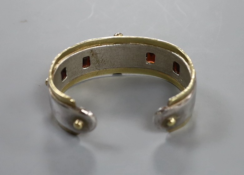 A modern parcel gilt silver and gem set open work bangle by Michael Allen Bolton, London, 1993, interior diameter 56mm, gross weight 67 grams.